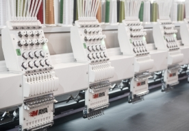 Multiple industrial embroidery machines in a row.