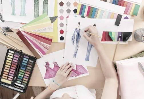 Person sketching fashion designs