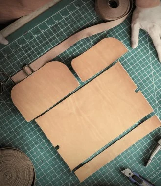 Leather pieces and tools on a cutting mat.