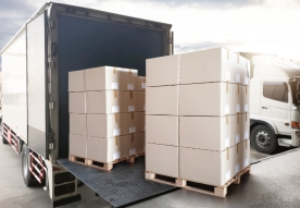 Stacked boxes being loaded into a delivery truck.