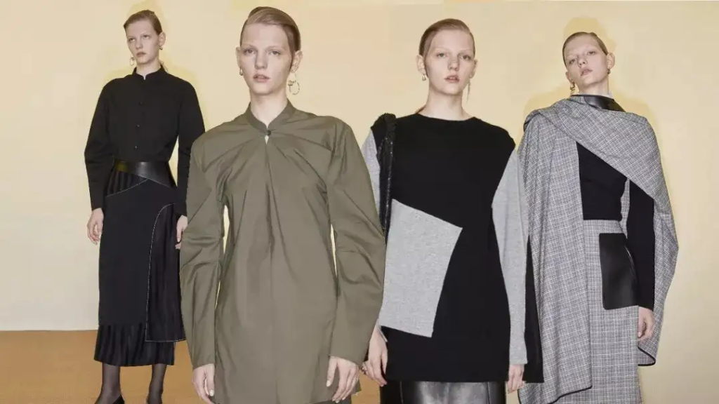 Four models showcasing a custom apparel collection with muted tones and architectural silhouettes.