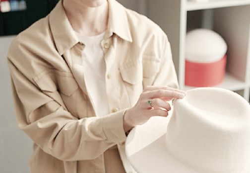 Person examining a white hat