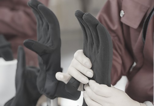 Hands inspecting black gloves closely