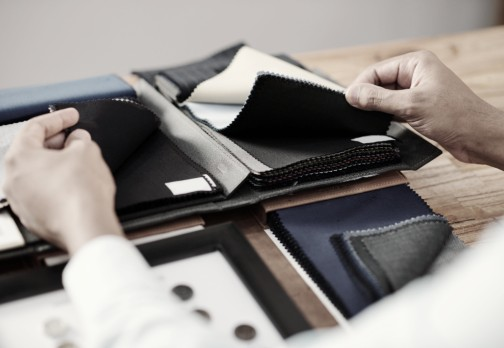 Hands selecting fabric samples from a book