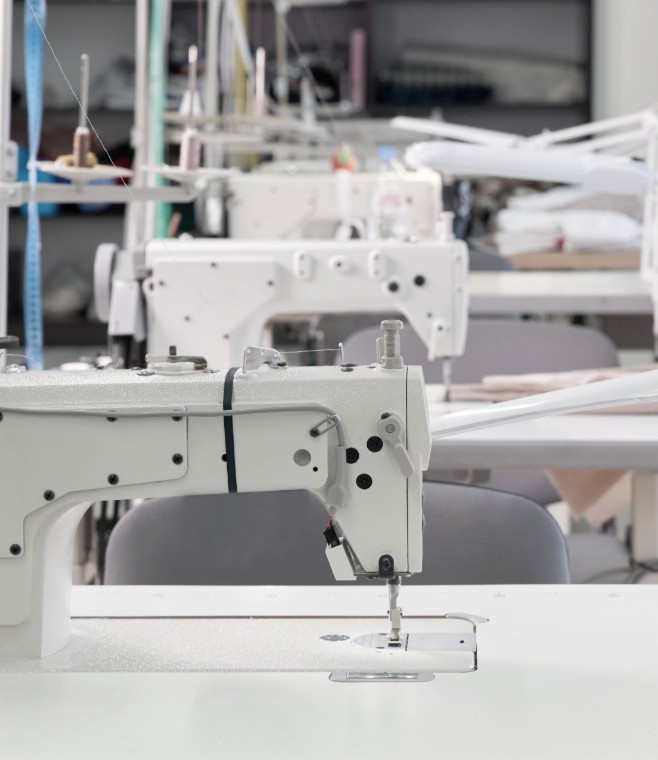 Row of industrial sewing machines in a glove factory.
