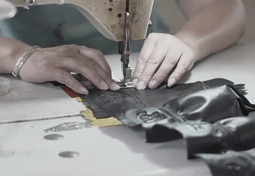Hands sewing leather on a sewing machine