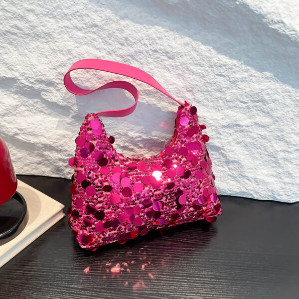 Hot-pink glitter purse on tabletop, angled view