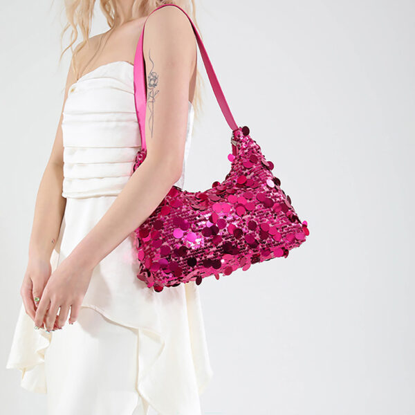 Model wearing pink sequin evening bag on shoulder