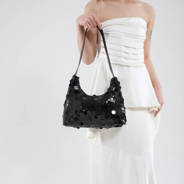 Model holding black sequin party purse, front view