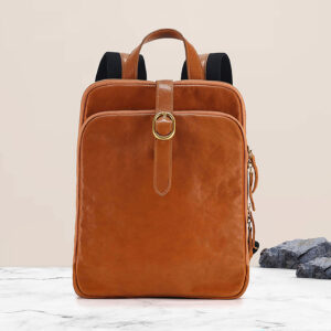 Tan leather commuter rucksack, front on tabletop