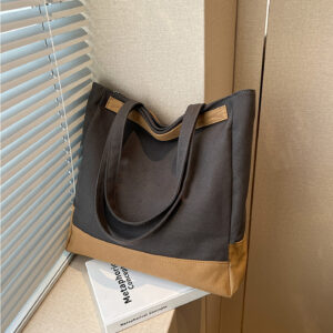 Dark grey canvas tote bag with camel base, window display