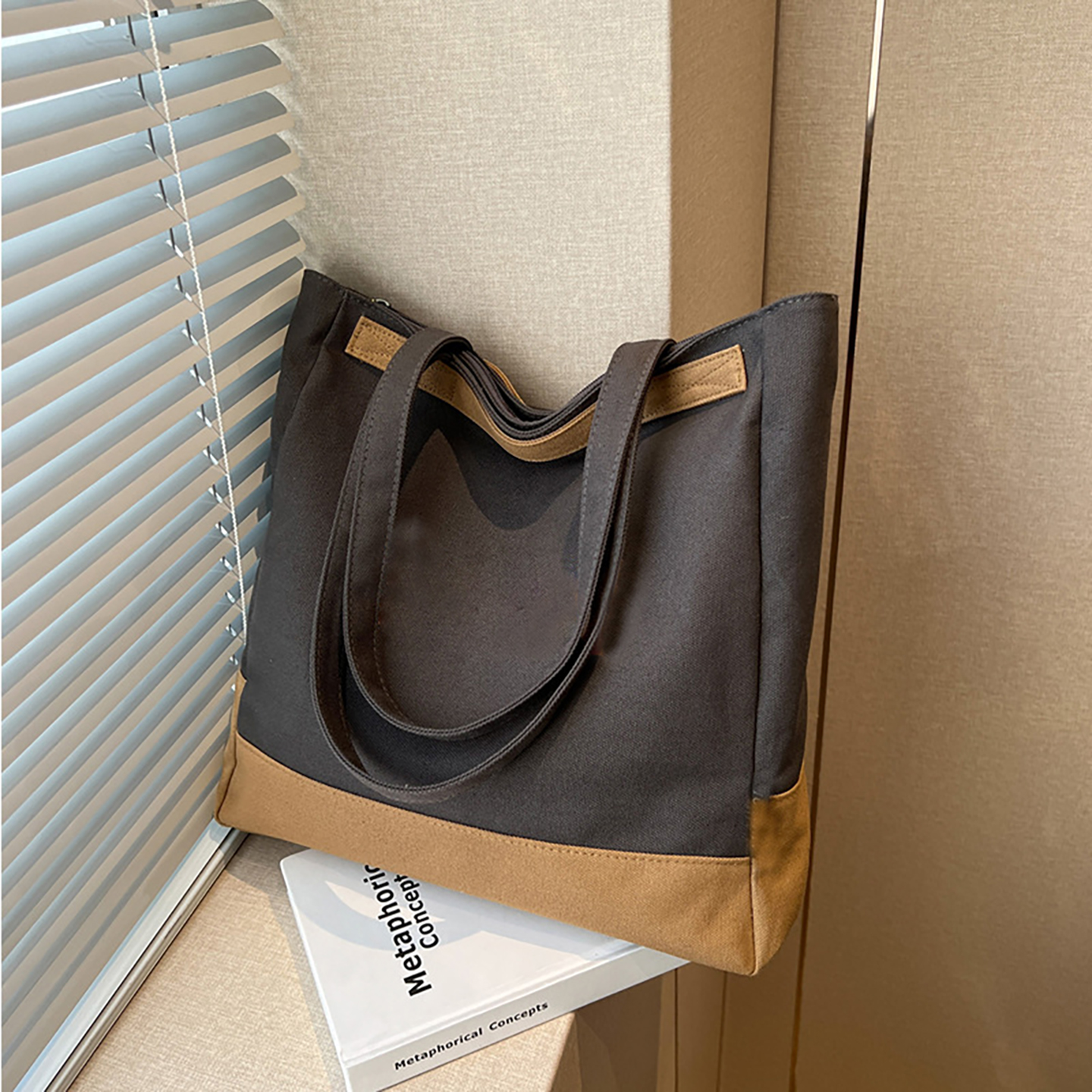 Dark grey canvas tote bag with camel base, window display