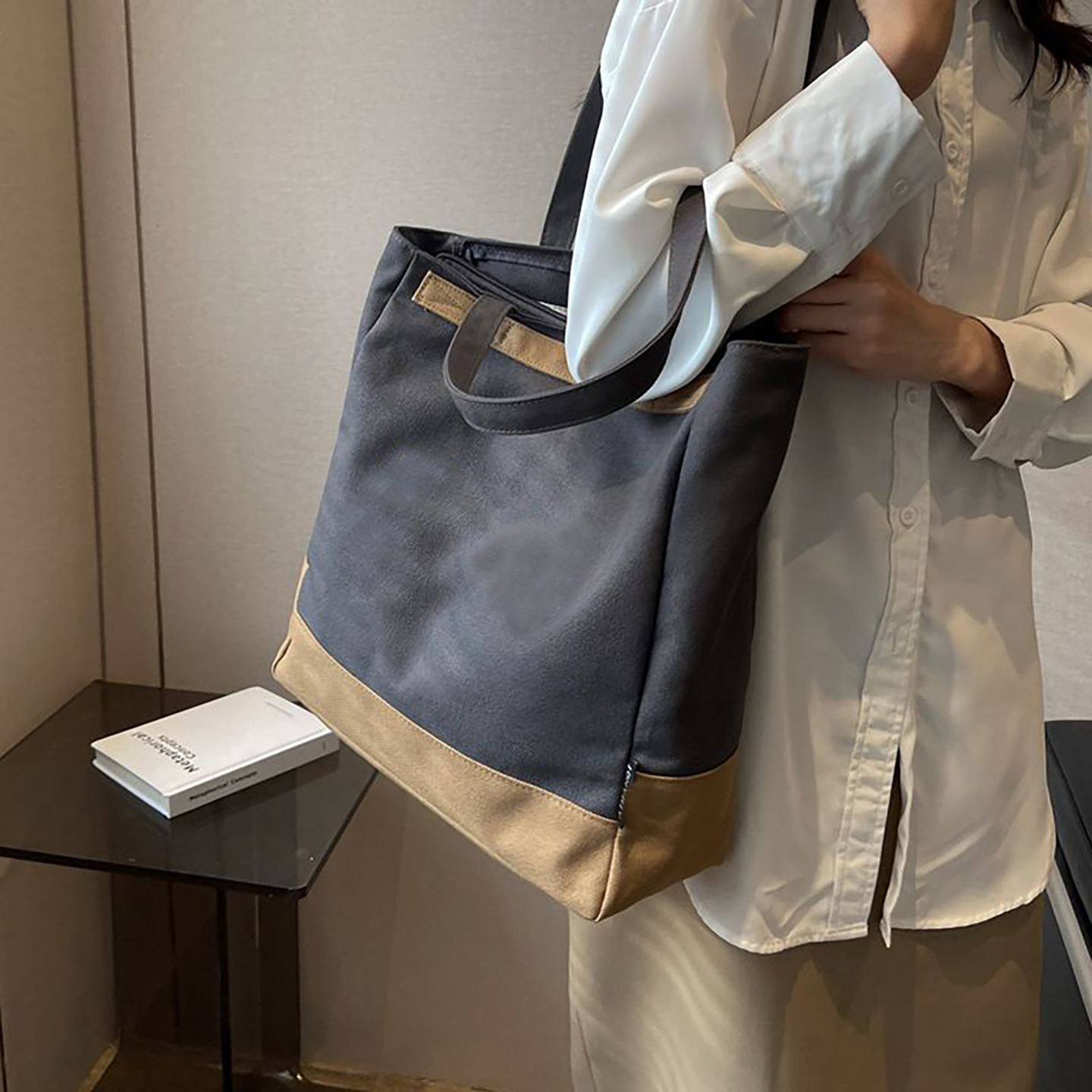 Model carrying dark grey canvas tote bag on shoulder