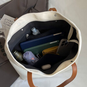 Interior view with snap top and organizer/zip pocket inside canvas tote bag.
