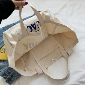 Interior view of oversized canvas tote with snap closure and organizer pocket.
