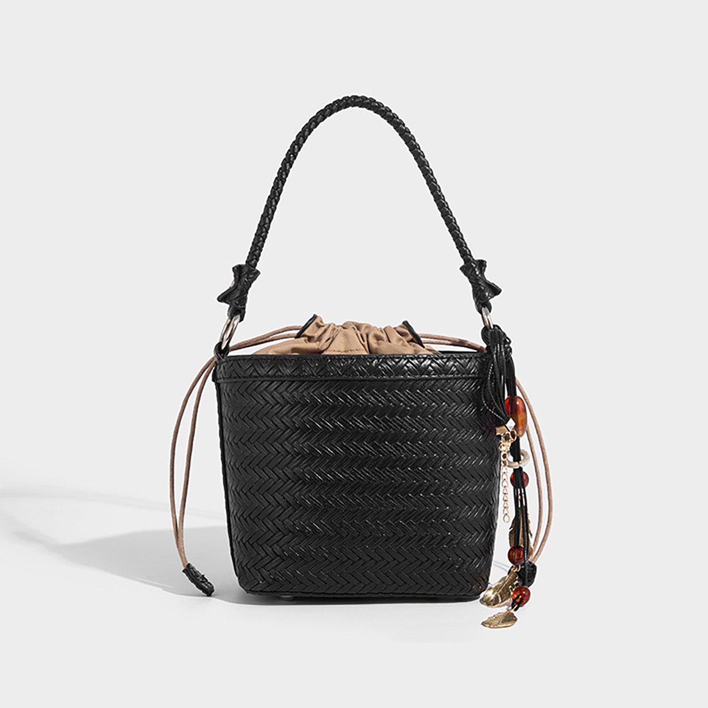Black woven bucket crossbody with braided handle and secure pouch closure.