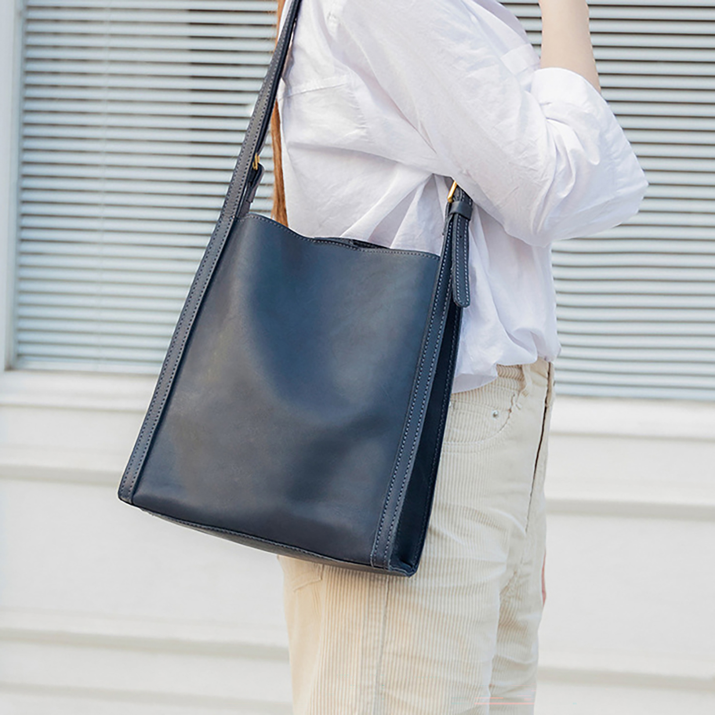 Lifestyle shot of navy leather hobo bag in casual setting