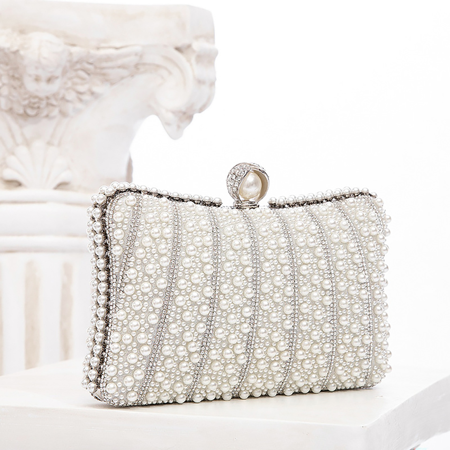 Side angle of pearl-embellished evening clutch purse in cage box design