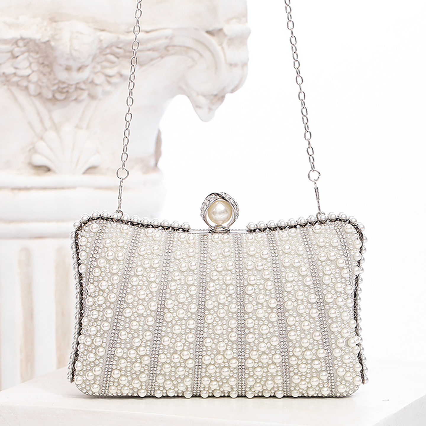 Crossbody view of evening clutch with detachable chain strap for versatile carry