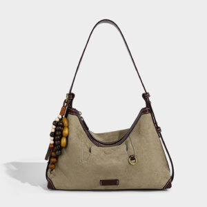 Front view of women's suede shoulder bag in khaki with ethnic charm