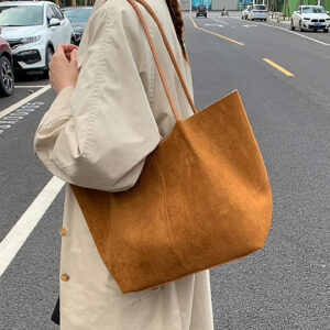 Side view of brown women's tote bag on shoulder during casual outing