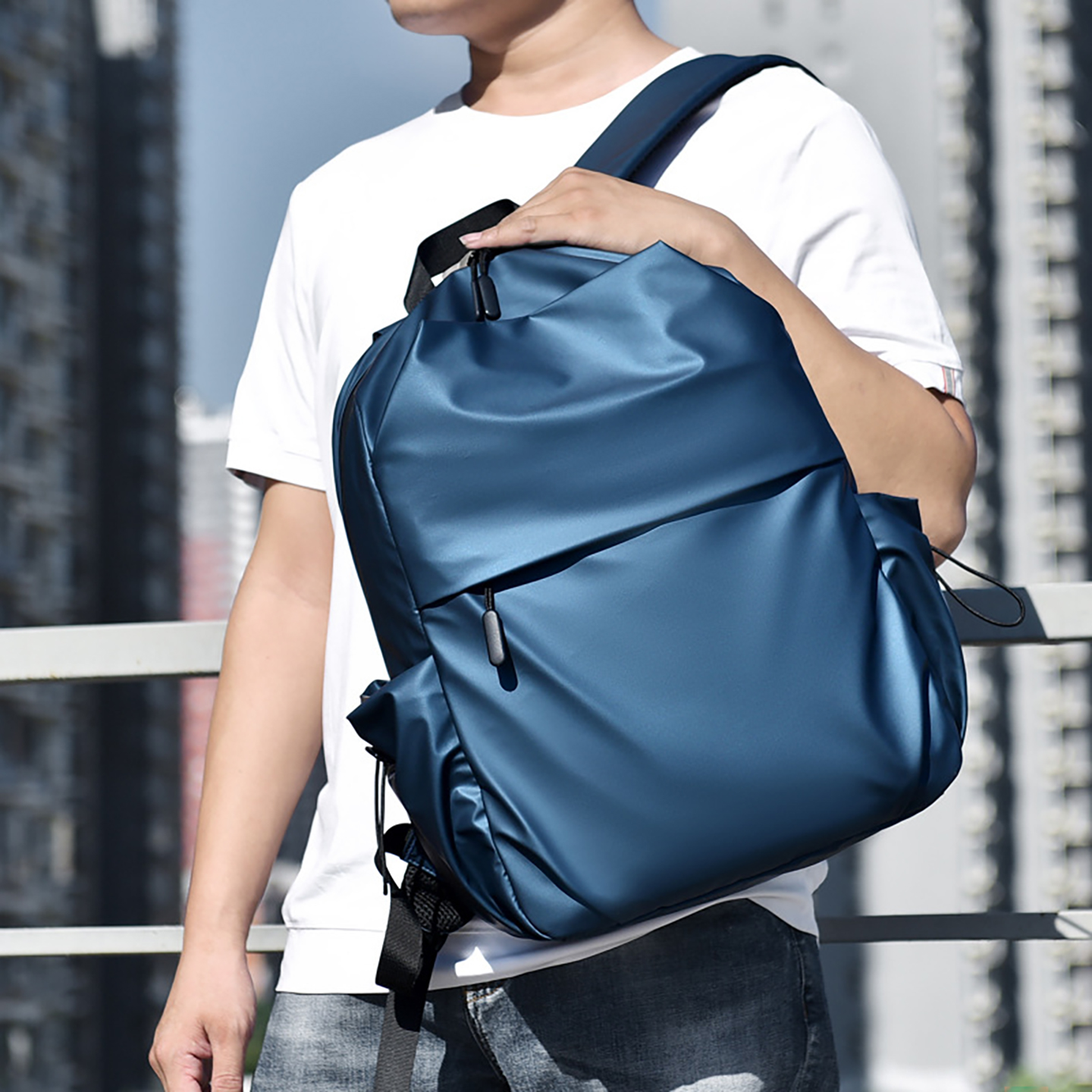 Model wearing navy men's laptop backpack in urban setting, demonstrating versatile street style for professionals and commuters.