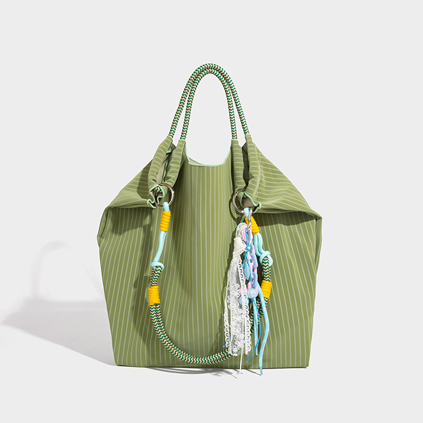 Front view of playful green women's bucket bag with vibrant striped pattern