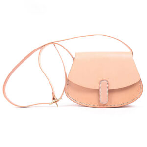 Front view of beige PU leather saddle bag with minimalist contrast color accents