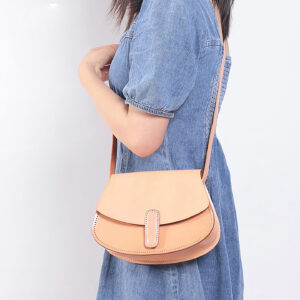 Model wearing beige saddle purse over shoulder for daily wear demonstration