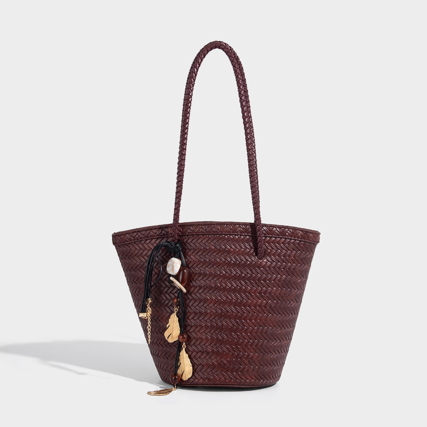 Maroon custom straw tote bag with gold leaf tassel and braided handles for vacation outfits