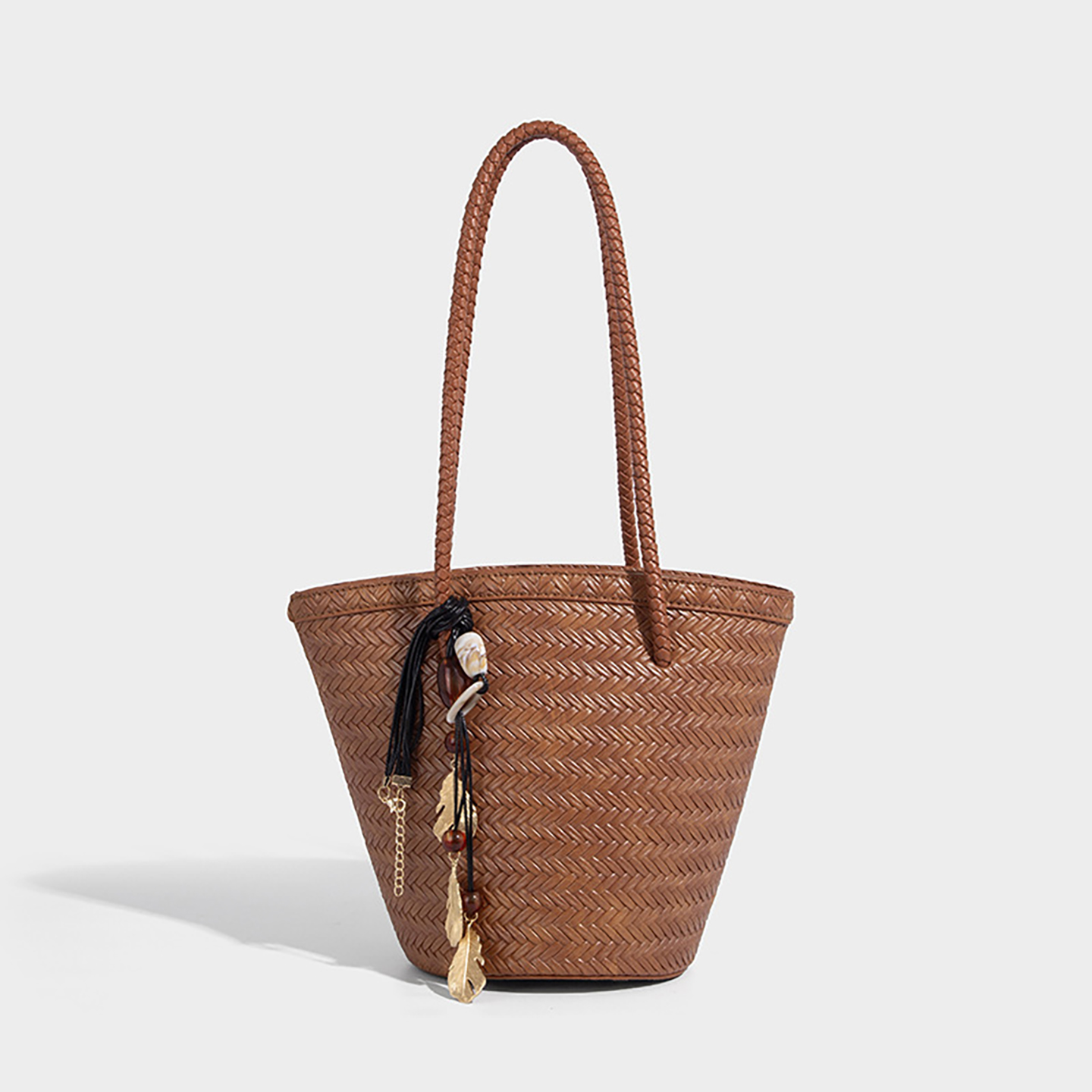 Light brown straw bucket bag with shell and bead tassel, ideal for summer leisure