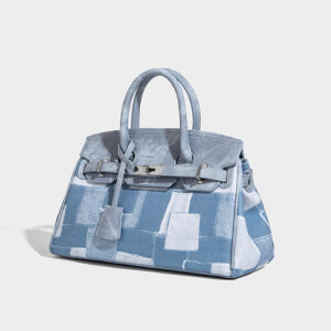 Angled perspective showing lock and straps on blue urban minimalist shoulder bag